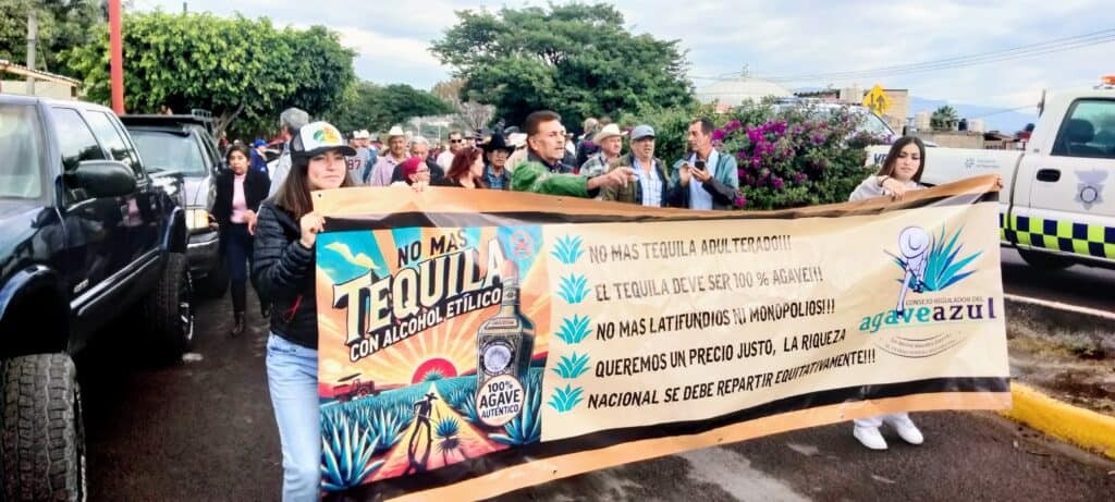 Protesters hold a banner accusing the tequila industry of corruption